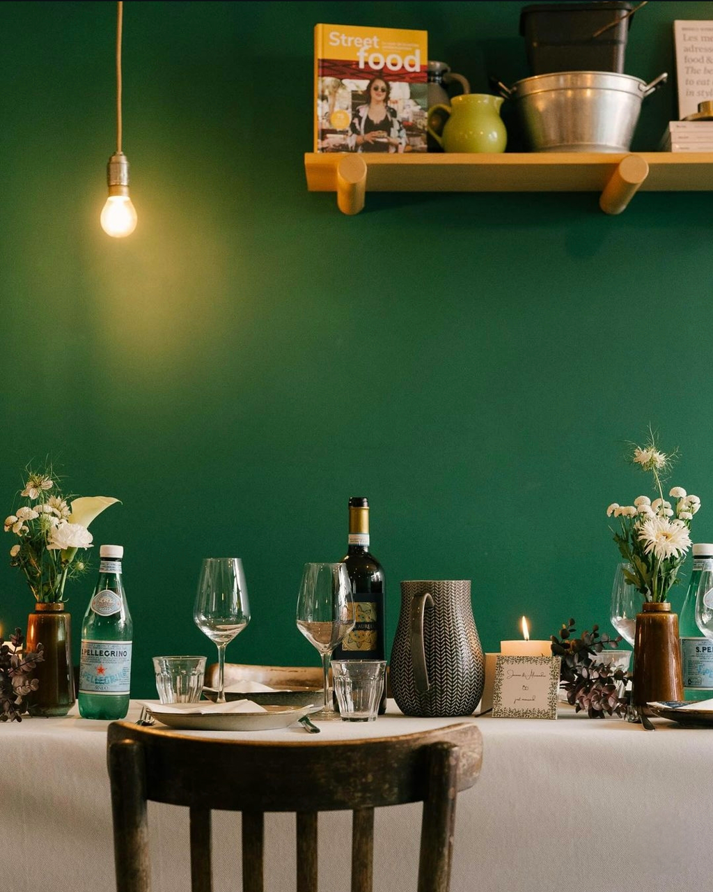 Set dinner table with flowers and wine against the deep green Kitchen 151 wall