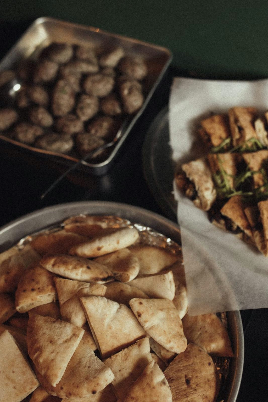 Sharing platters of kofta, warm pita and wraps on the table