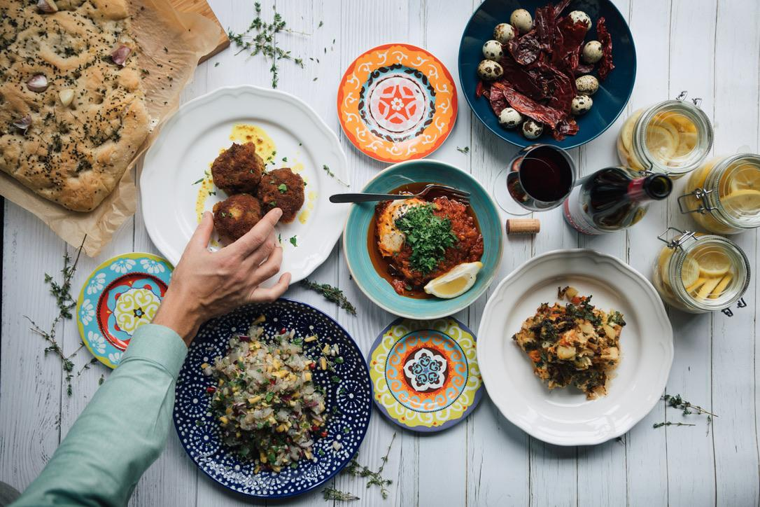 Overhead view of a Mediterranean sharing table with colourful plates and mezze